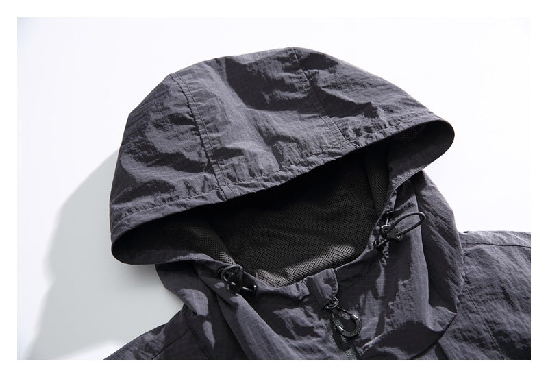 Close-up of the dark gray jacket's hood, showing mesh lining and adjustable drawcord hardware.