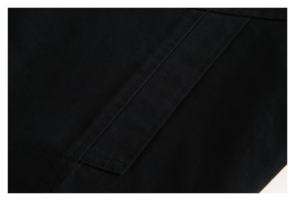 Close-up of a long black pocket flap and stitching on the jacket.
