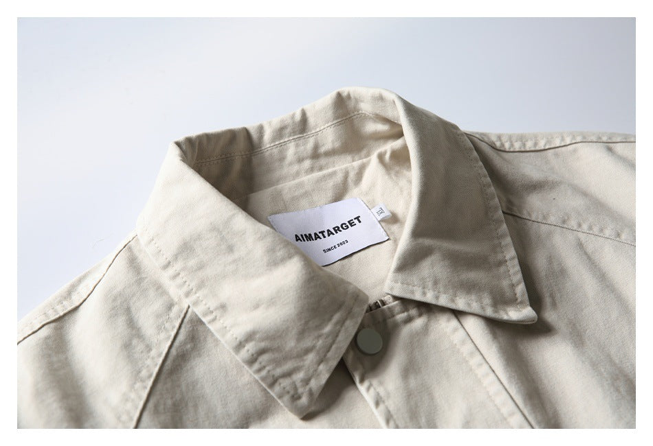 Close-up of an off-white jacket collar, front snap, stitching, and sewn AIMATARGET label.