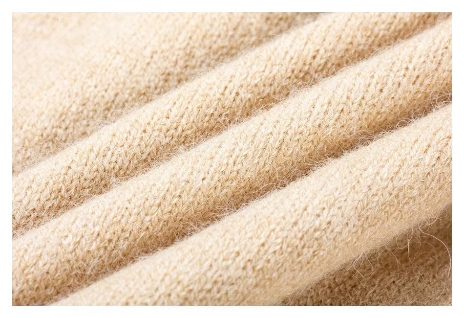 Close-up of a soft-looking beige knit garment, showing fuzzy fibers and textured stitches.