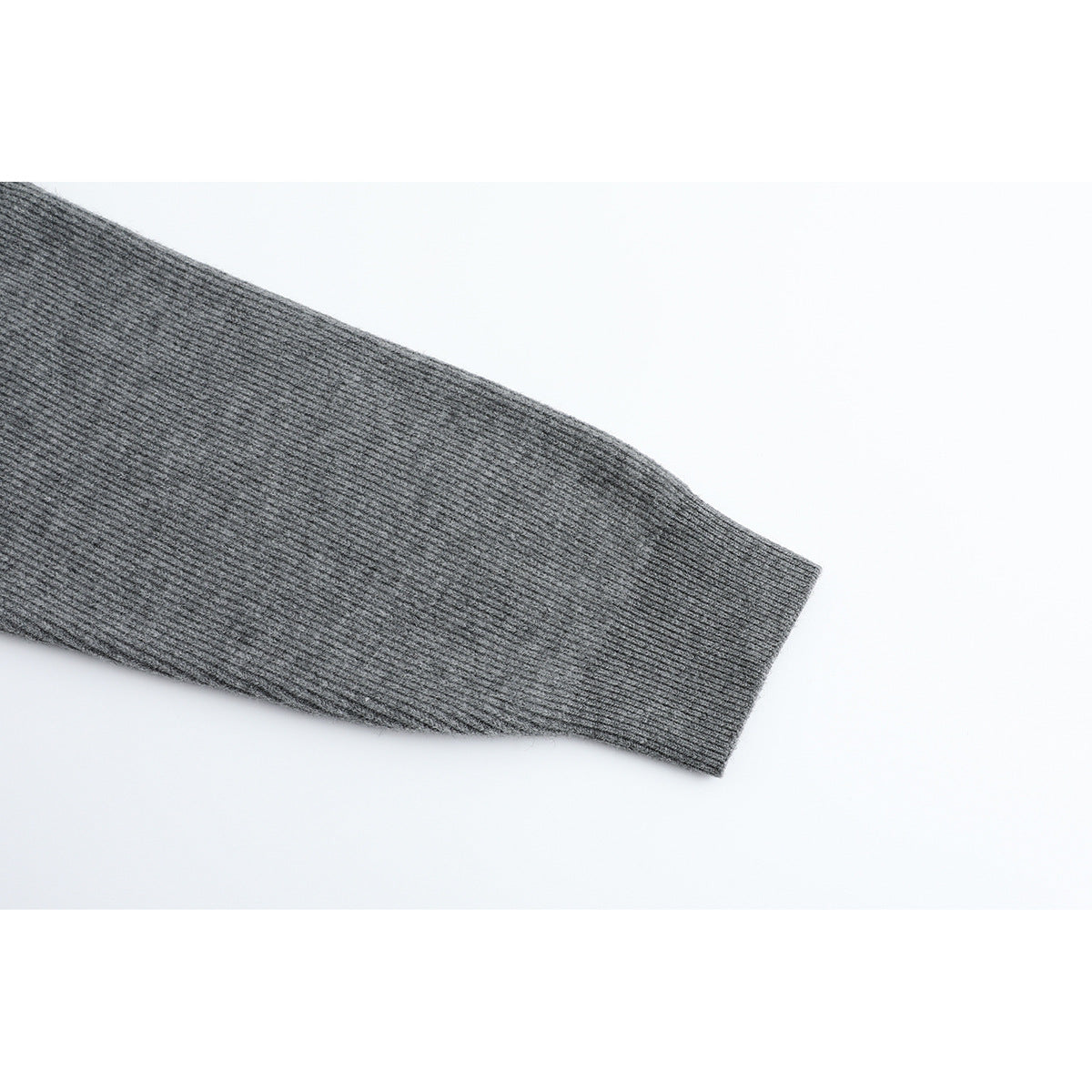 Close-up of a gray ribbed sweater sleeve ending in a wide cuff.