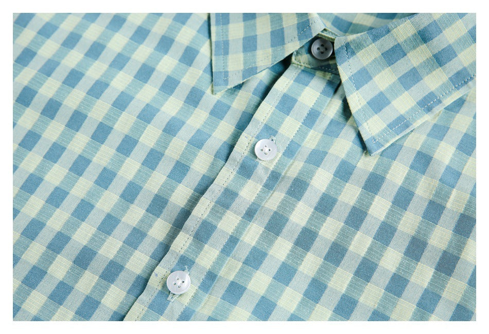 Close-up of the button placket, collar, and gingham pattern on a teal-and-pale-yellow shirt.
