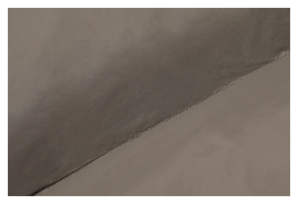 Close-up of taupe jacket fabric and a diagonal stitched seam.