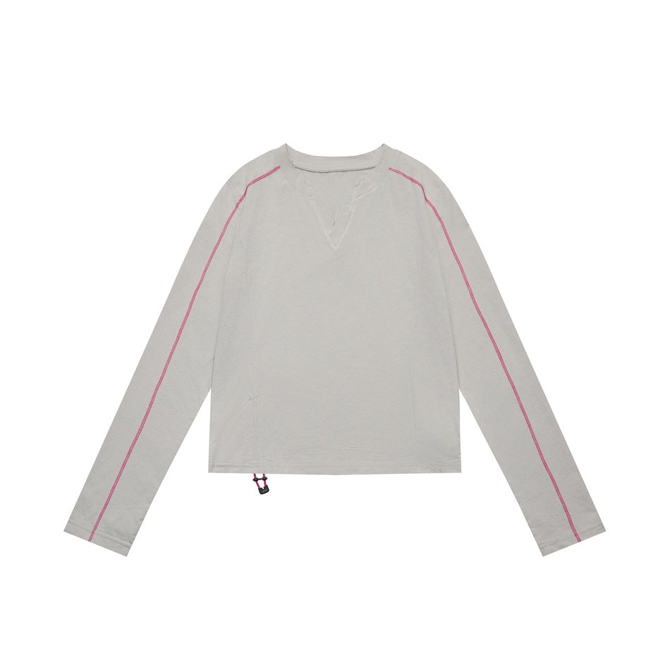 Light gray cropped long-sleeve top flat lay with pink contrast stitching on the sleeves and a hem drawstring toggle