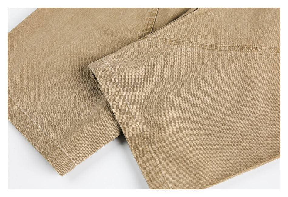 Close-up of tan pant legs overlapping, showing the fabric texture and finished hems.