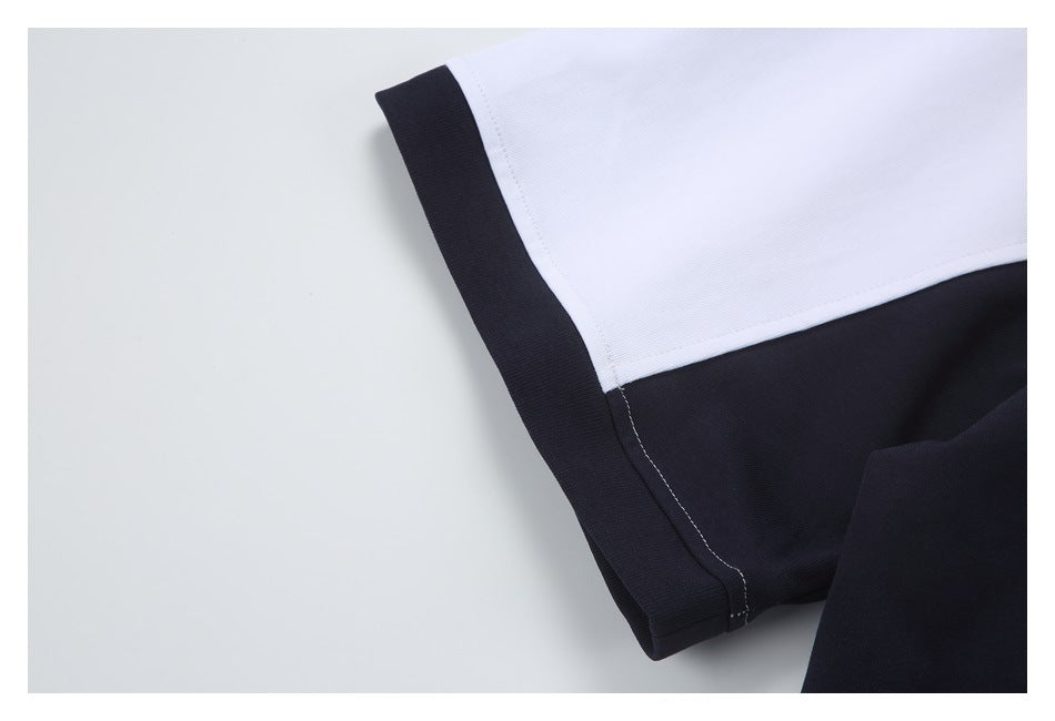 Close-up of a white-and-black shirt sleeve with a black cuff and color-blocked panel.