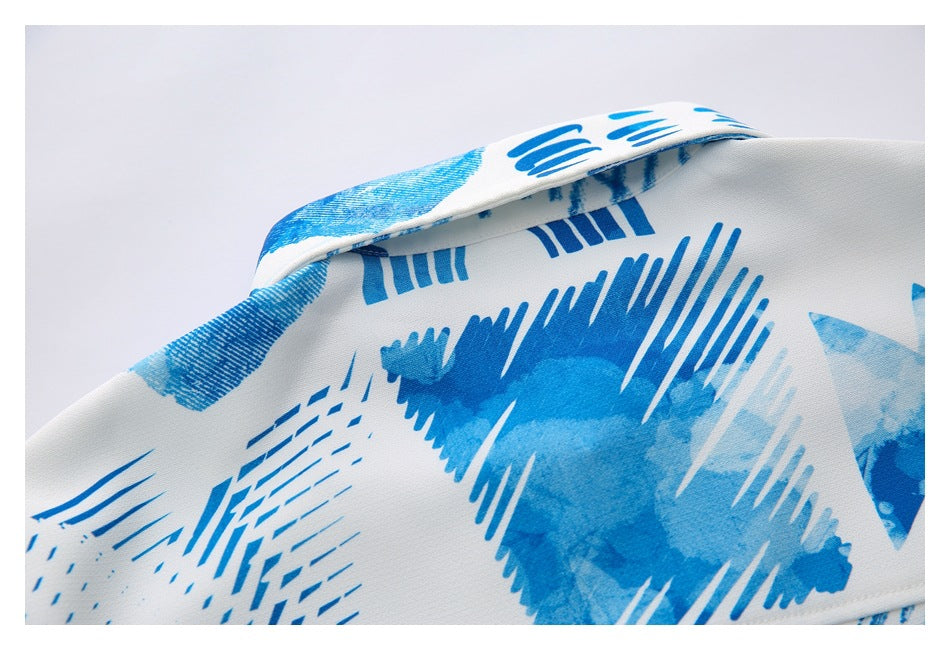 Close-up of the shirt's folded collar and abstract blue print on white.