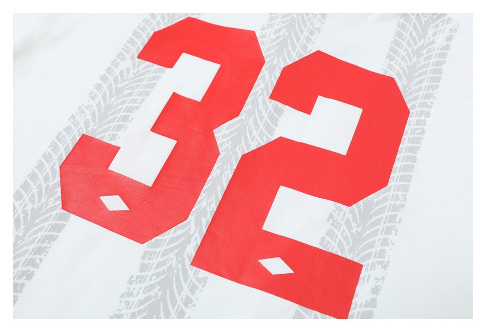 Close-up of a white shirt with a large red number 32 over a light gray tire-track pattern.