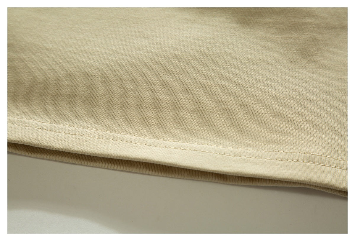 Close-up of a light beige garment hem with neat double stitching.