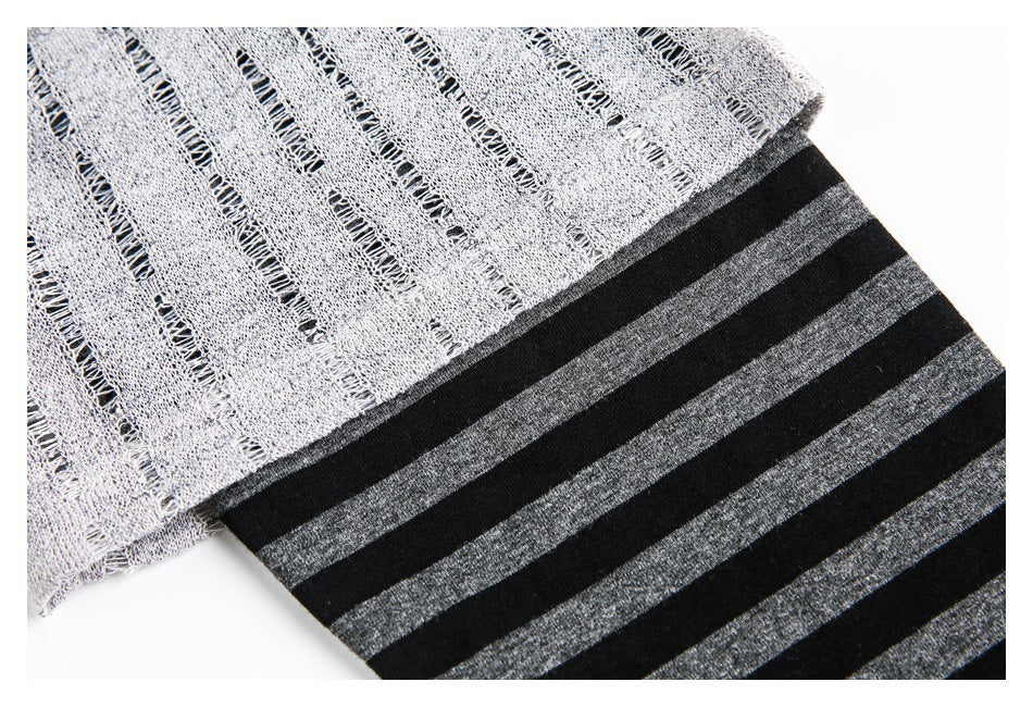 Close-up of light gray open-knit fabric meeting a black and charcoal striped section.