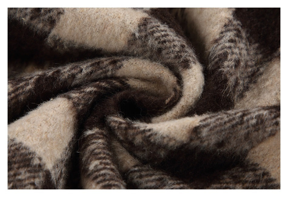 Close-up of brown and beige plaid fabric folded to show its fuzzy texture.