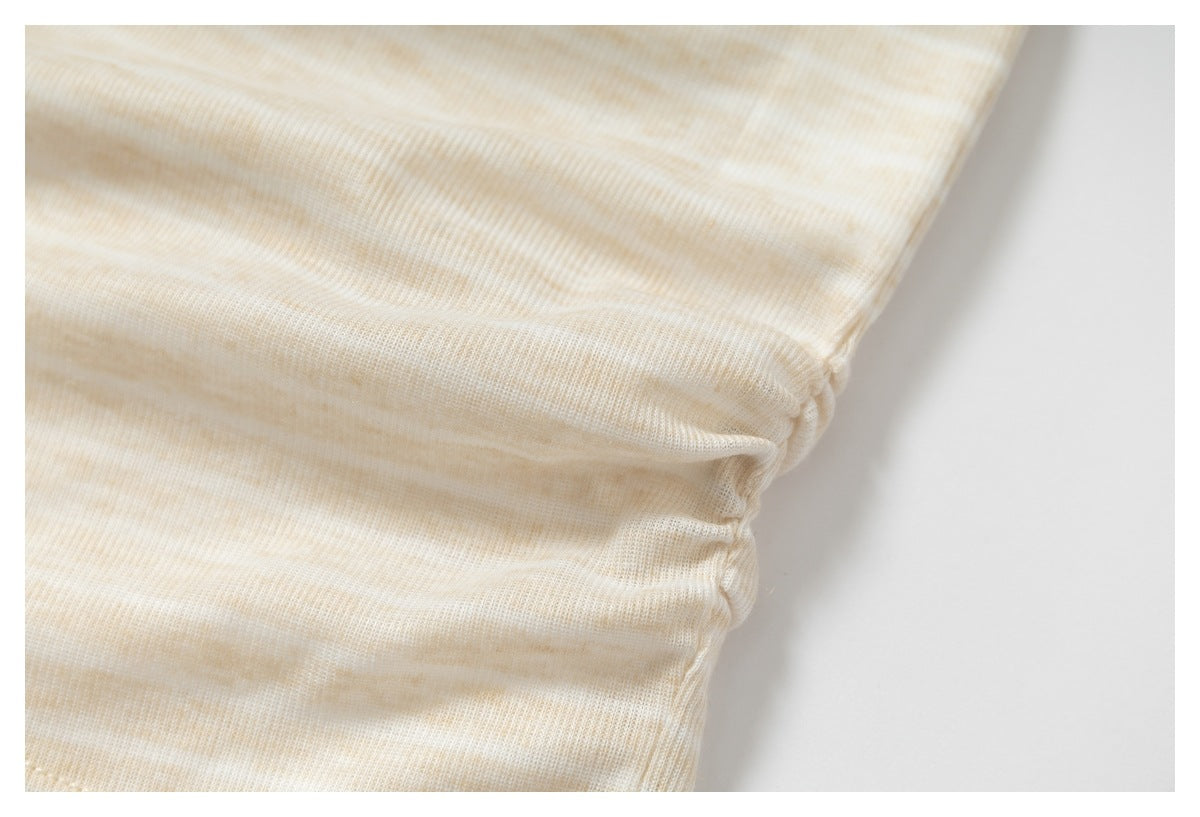 Close-up of cream and beige striped knit fabric gathered along a seam.