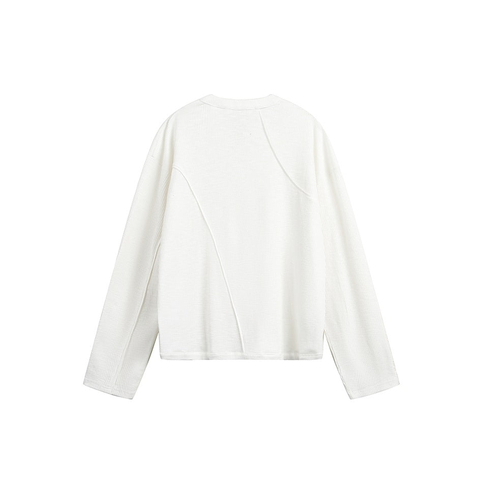 Back view of a white ribbed long-sleeve top with curved seam detailing, shown flat against white.