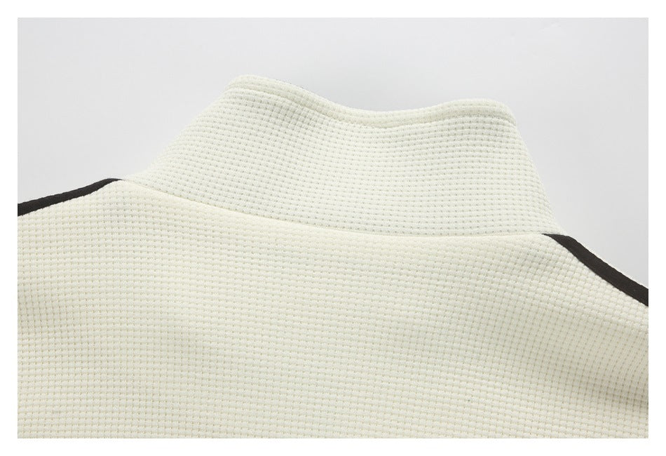 Close-up of an off-white textured garment collar with dark edging.