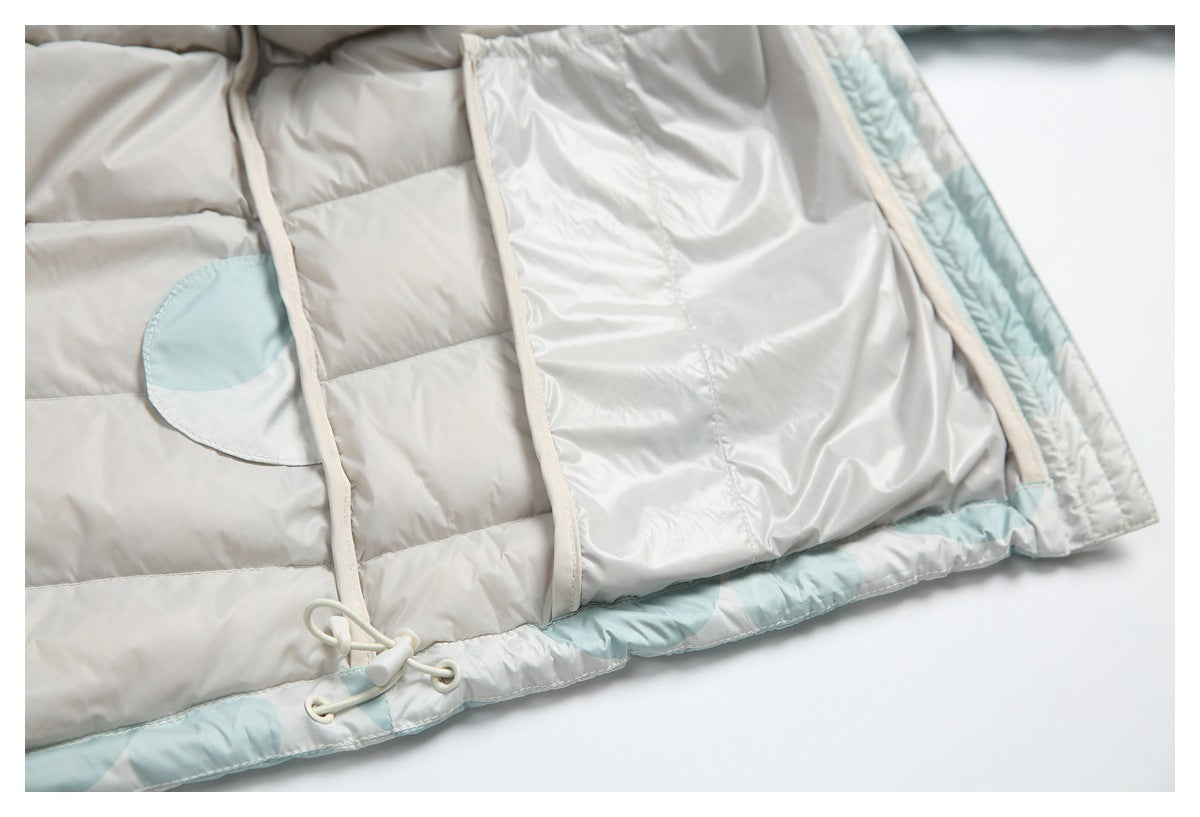 Close-up of the jacket's pale gray quilted interior and hem, with pale aqua accents and an elastic drawcord toggle.