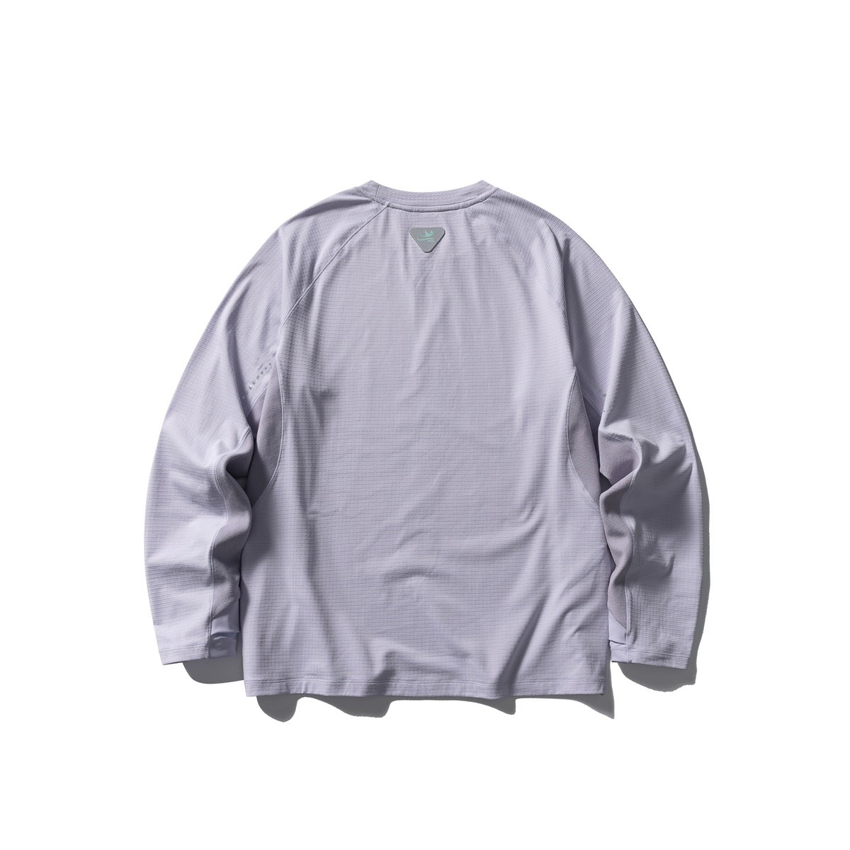 Back view of a pale lavender long-sleeve raglan shirt with a small upper-back patch and reflective sleeve dots.
