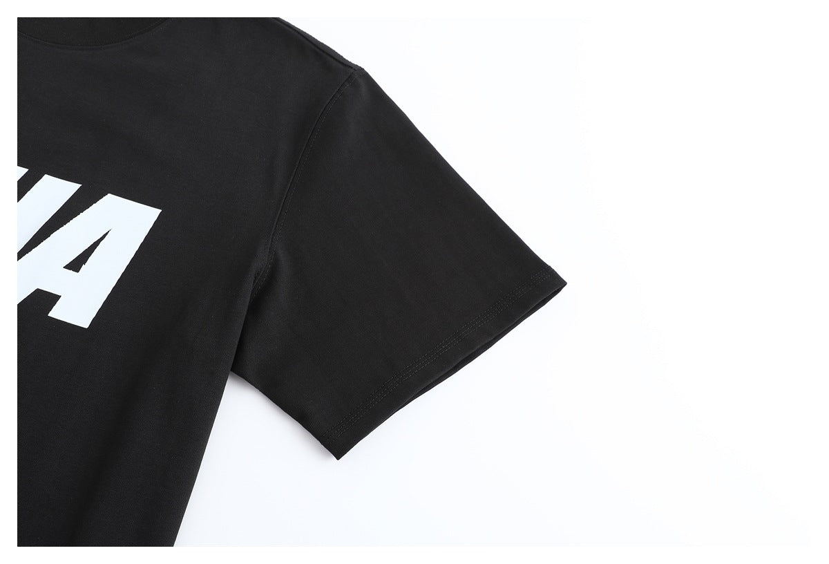 Close-up of a black T-shirt's short sleeve, stitched hem, and partial white chest print.