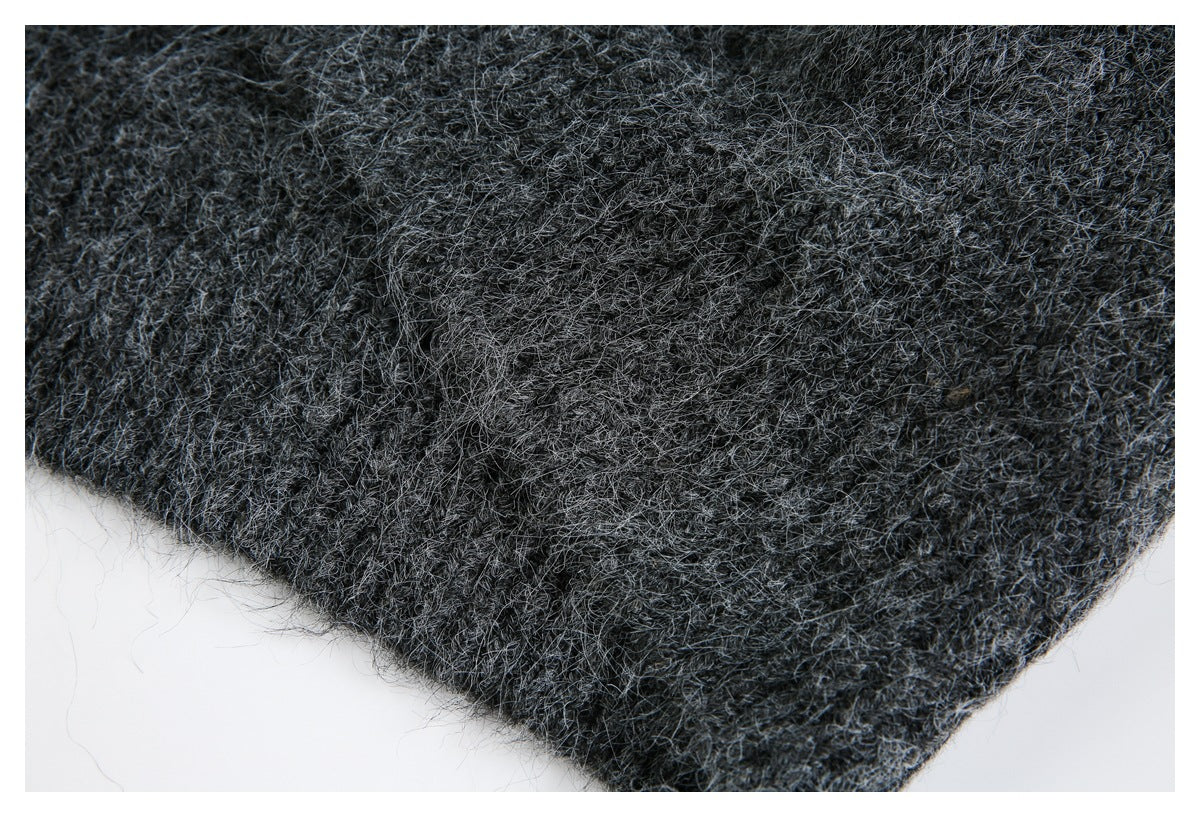 Close-up of the fuzzy charcoal gray knit garment's edge and textured surface.