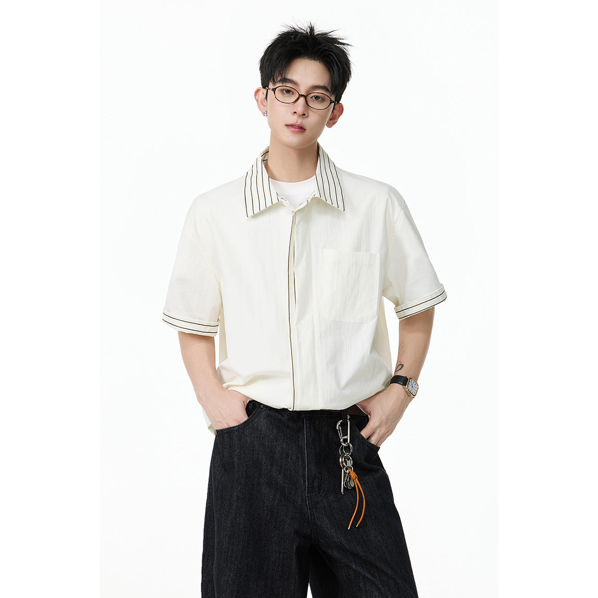 Closer view of an ivory short-sleeve button-up shirt with a striped collar, trimmed cuffs, and a chest pocket.