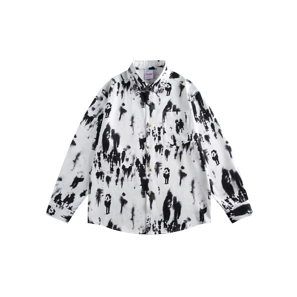 Flat lay of a white long-sleeve button shirt with a black blurred-figure print and a chest pocket