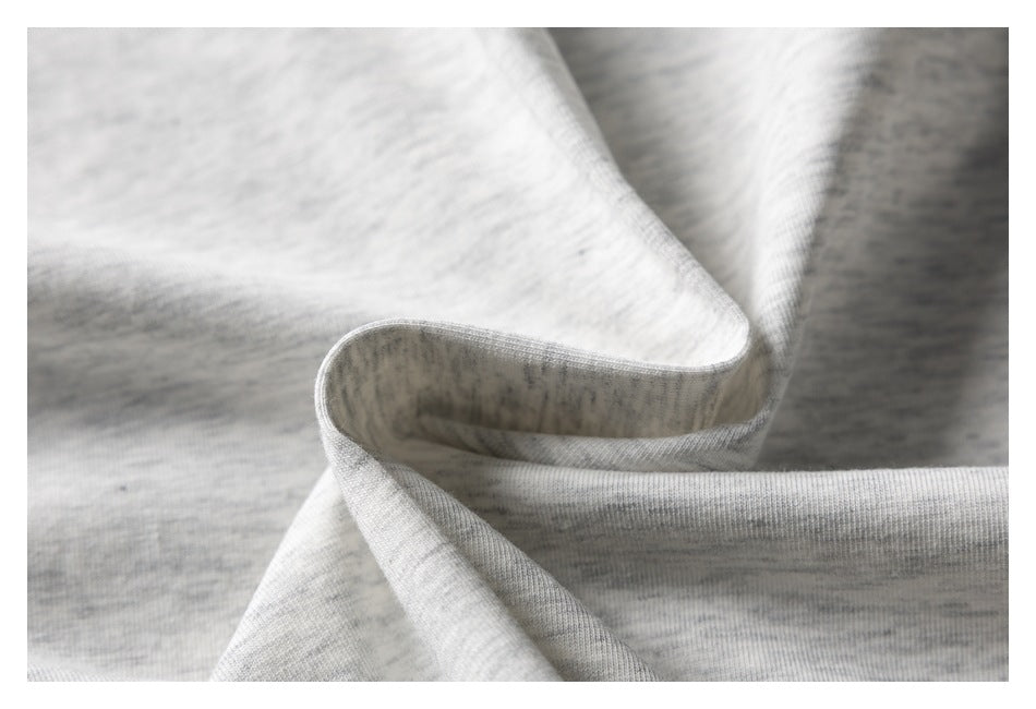 Close-up of light gray heathered fabric folded to show its texture and edge.