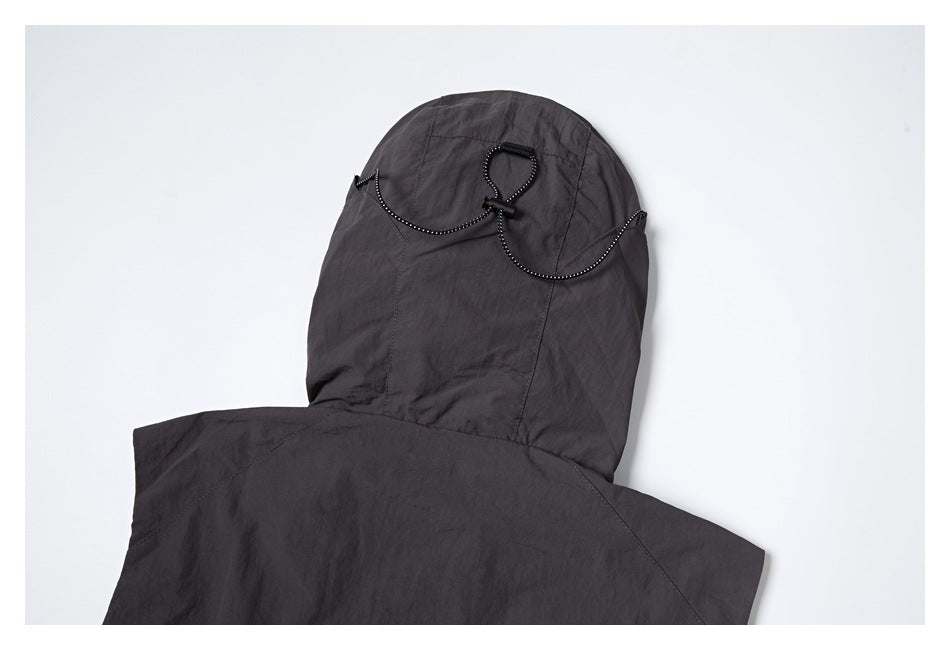 Close-up of a charcoal hood with curved black-and-white cord trim and a loop detail.