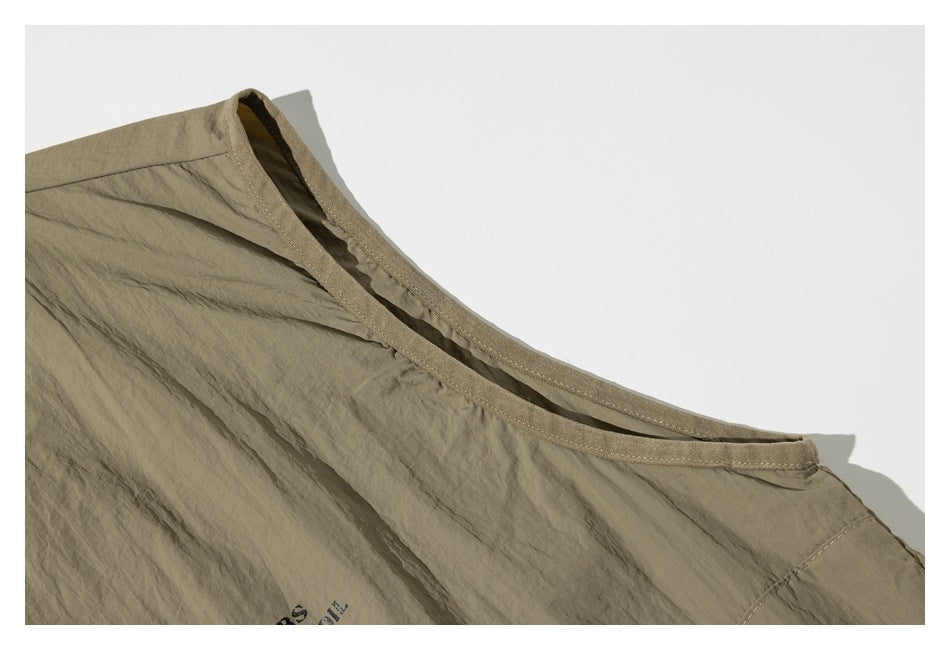 Close-up of the back neckline and stitched binding on an olive-taupe garment.