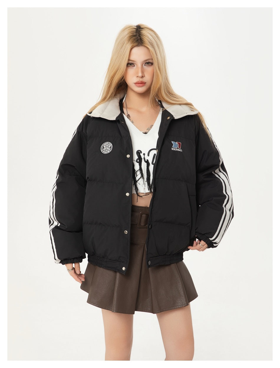 Closer front view of a model wearing a black padded jacket with white sleeve stripes and a light collar.