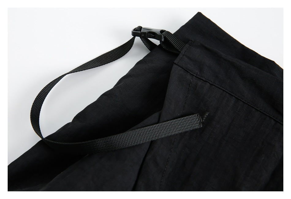 Close-up of a black webbing strap and plastic buckle attached to the skirt.