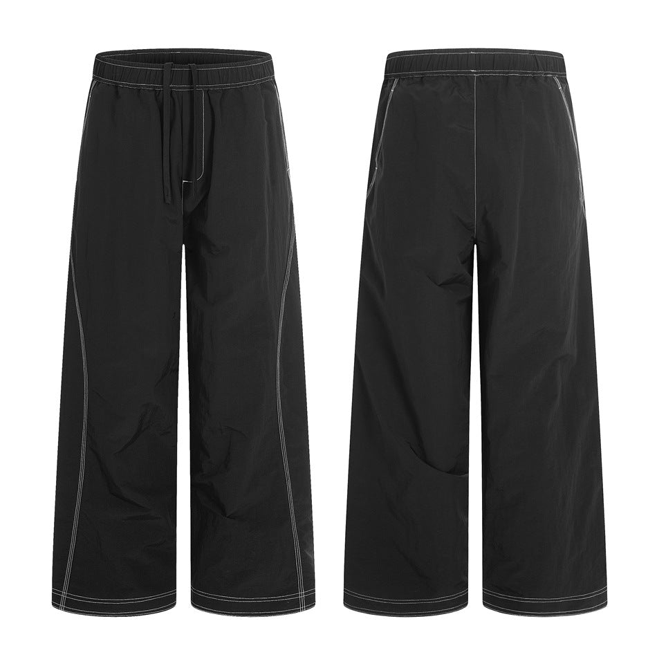 Black wide-leg pants shown from the front and back, with an elastic drawstring waist and white contrast stitching.