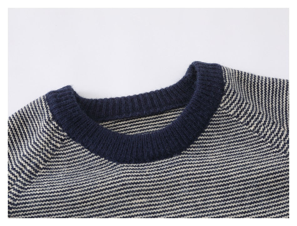 Close-up of the navy ribbed crew neck and striped knit body of a sweater.
