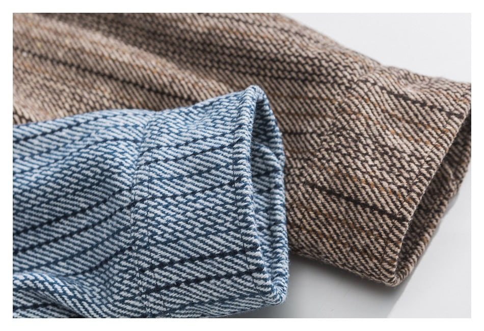 Close-up of folded blue and brown striped shirt cuffs showing their stitched edges.
