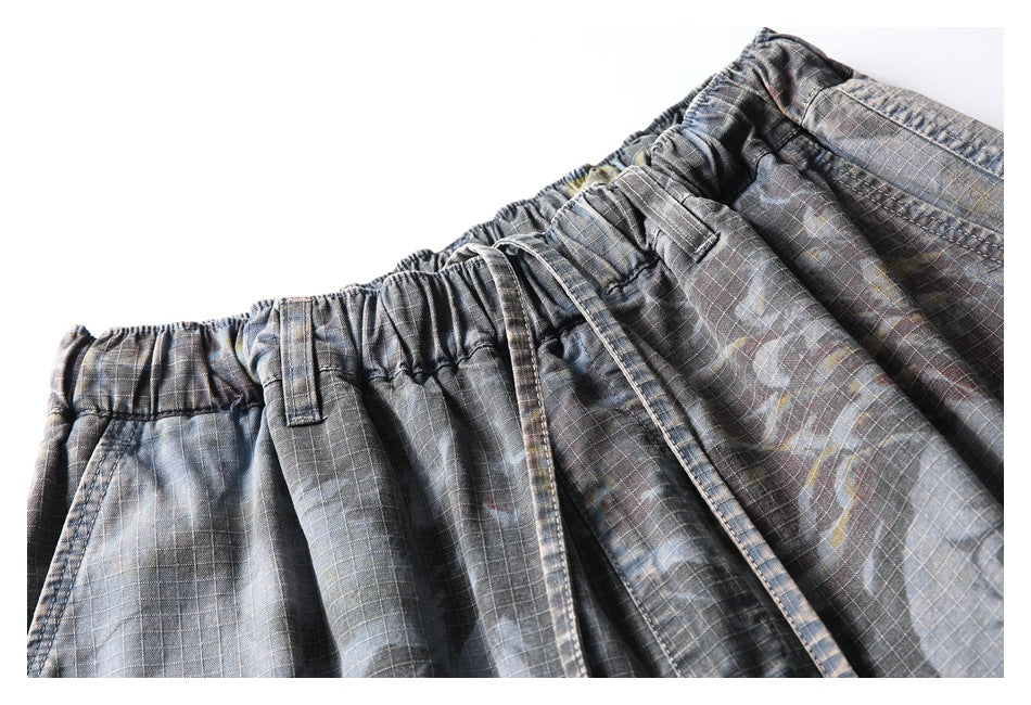 Close-up of the gray patterned shorts’ elastic waistband, belt loops, drawstring, and checked fabric.