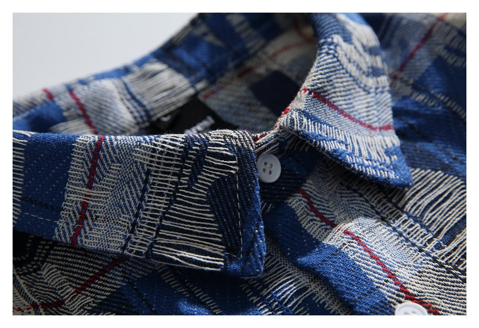 Close-up of the plaid shirt's collar and white buttons, showing blue, black, cream, and thin red checks.