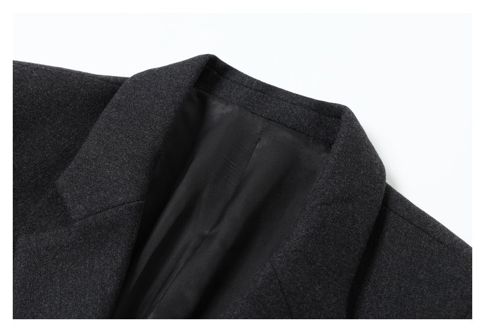 Close-up of the charcoal gray coat’s notched lapel and black lining.