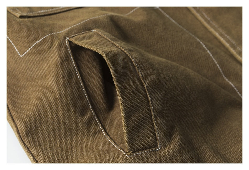 Close-up of a brown jacket pocket opening with a stitched fabric welt.