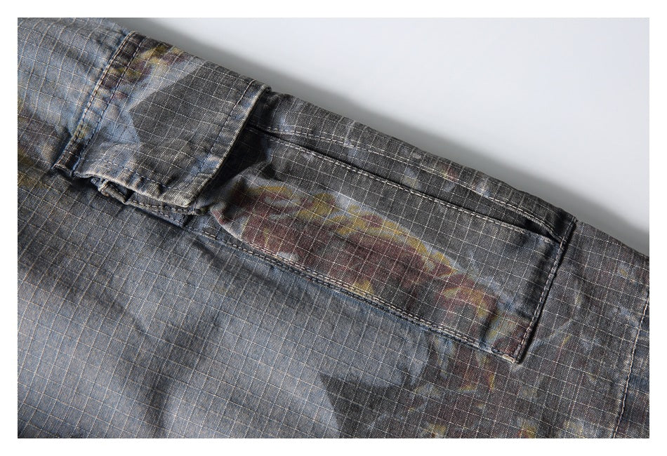 Close-up of the back of gray plaid shorts showing a welt pocket and belt loop.