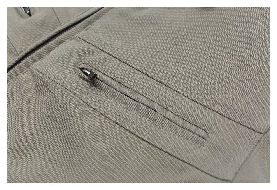Close-up of a long zippered pocket on the beige jacket.