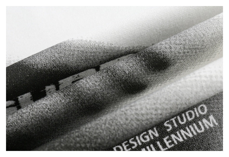 Extreme close-up of textured white fabric over a black-and-gray printed graphic with partial English text.