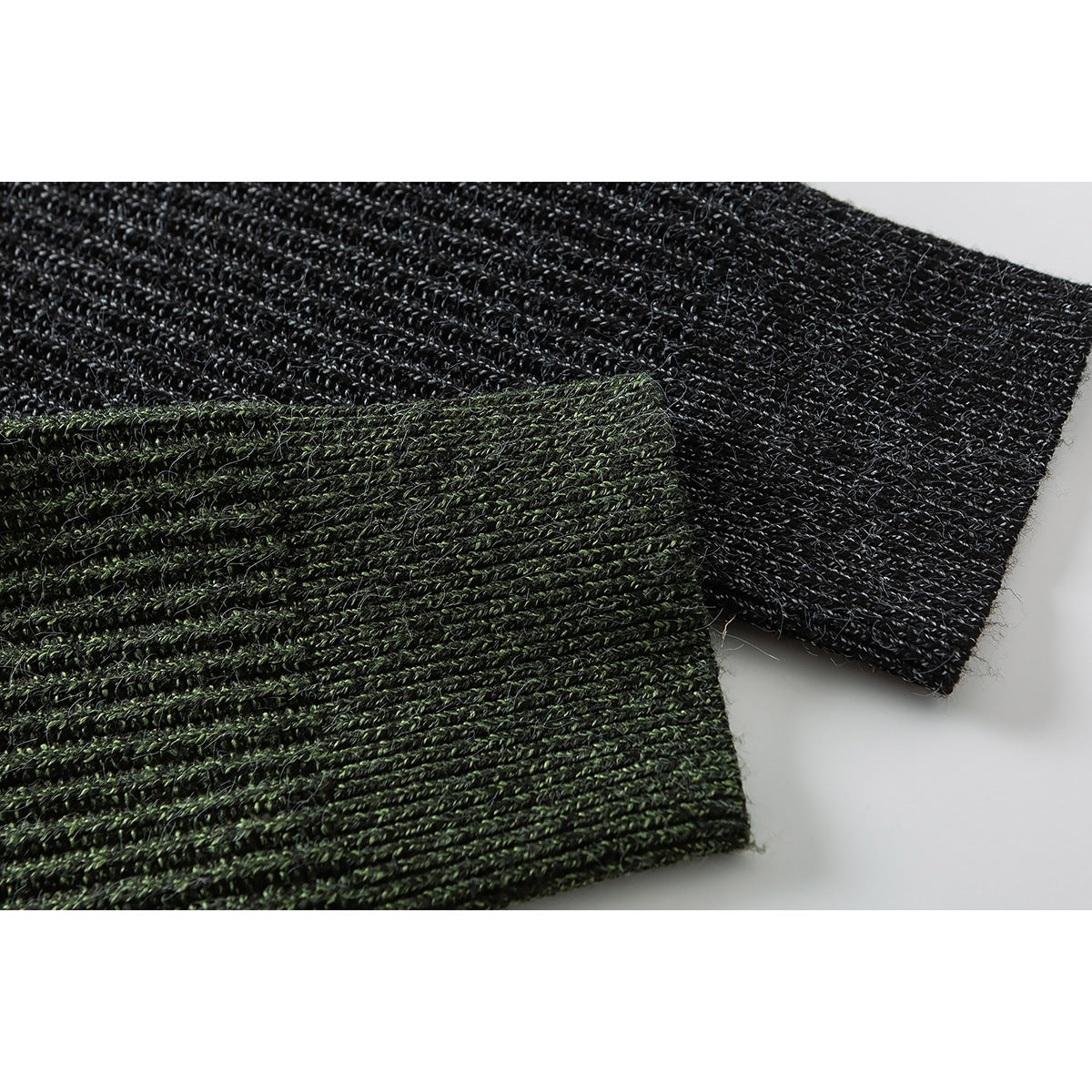 Close-up of rib-knit sweater cuffs in dark green and charcoal gray.