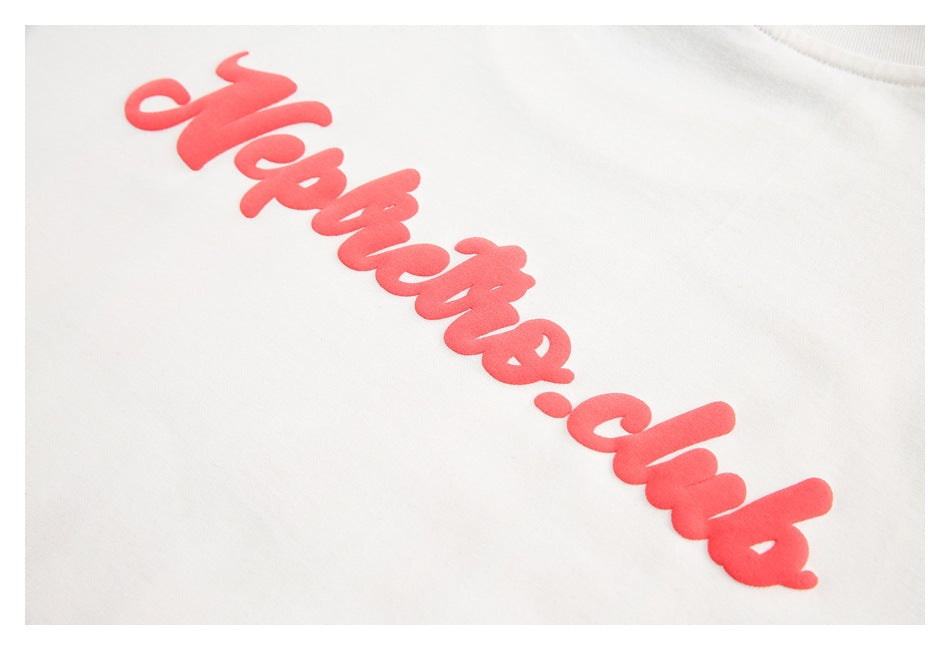 Close-up of raised red script lettering printed on white fabric.