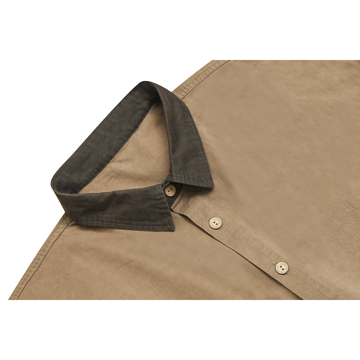 Close-up of a tan shirt with a dark contrasting collar and light buttons.