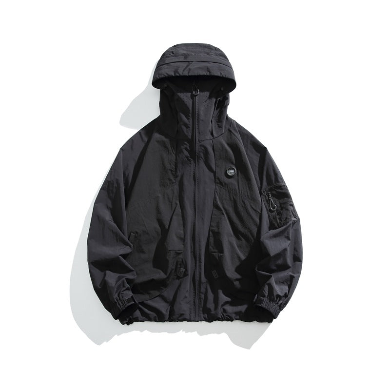 Black hooded zip-up lightweight jacket flat lay with chest patch and sleeve pocket