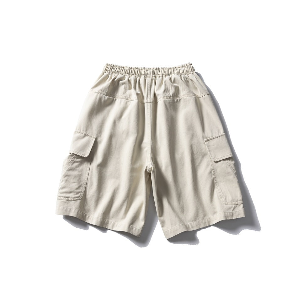 Back view of cream cargo shorts laid flat, showing an elastic waistband and large side pockets.