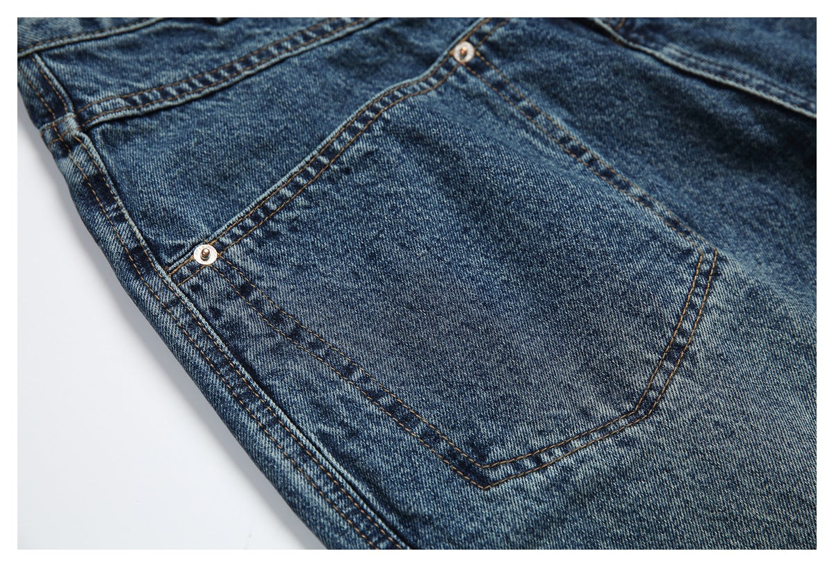 Close-up of a back pocket on blue-wash jeans, with visible stitching and a metal rivet.
