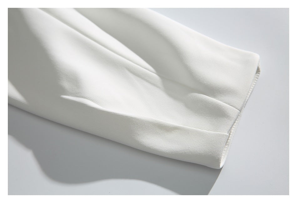 Close-up of a white sleeve ending in a plain stitched cuff.
