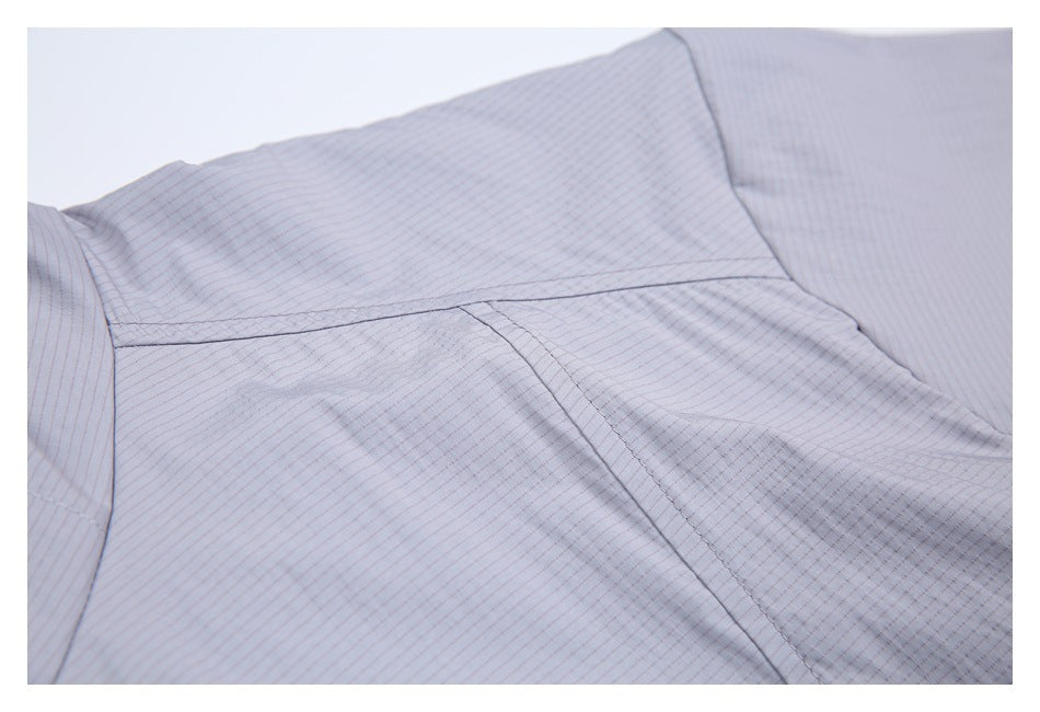 Close-up of pale gray-lavender jacket fabric showing fine pinstripes and stitched panel seams.