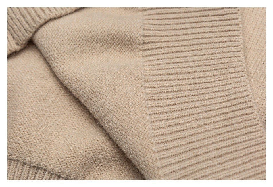 Close-up of a beige sweater seam beside a wide ribbed knit trim.