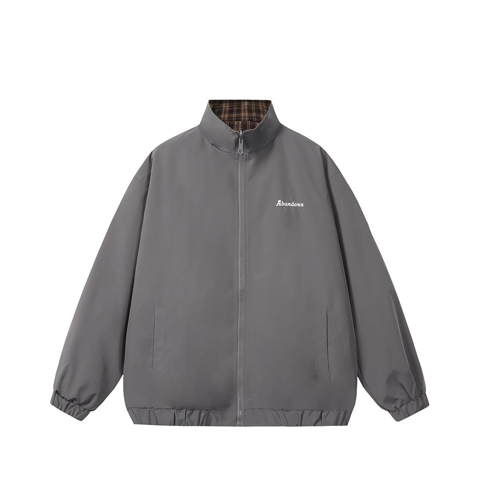 Gray reversible stand-collar zip jacket, front view, with brown plaid inner collar and small white chest embroidery
