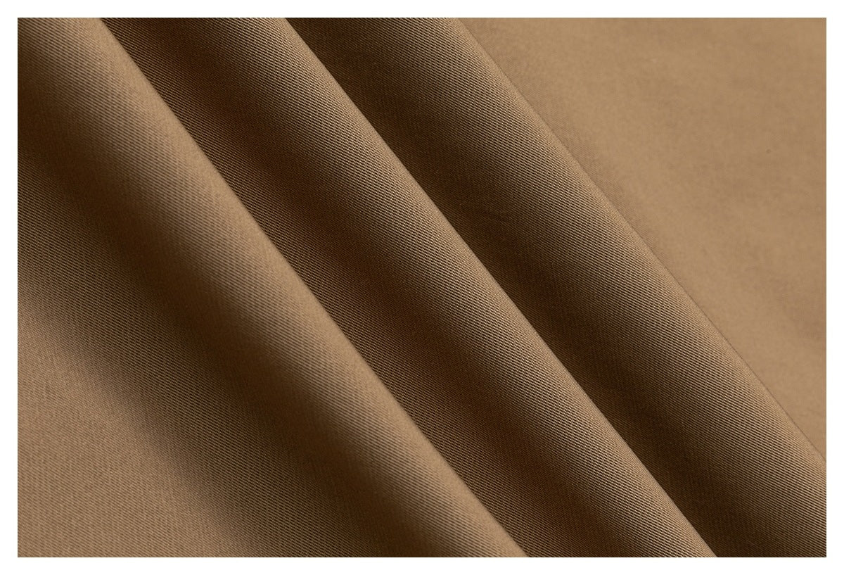 Close-up of brown fabric draped in soft folds, showing its fine diagonal weave.
